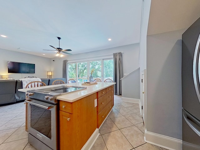 1324 Branch St, Tallahassee, FL 32303 - kitchen with appliances with stainless steel finishes, light tile patterned flooring, brown cabinetry, light countertops, and a ceiling fan