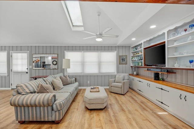 living room featuring light hardwood / wood-style floors, ceiling fan, a healthy amount of sunlight, and lofted ceiling