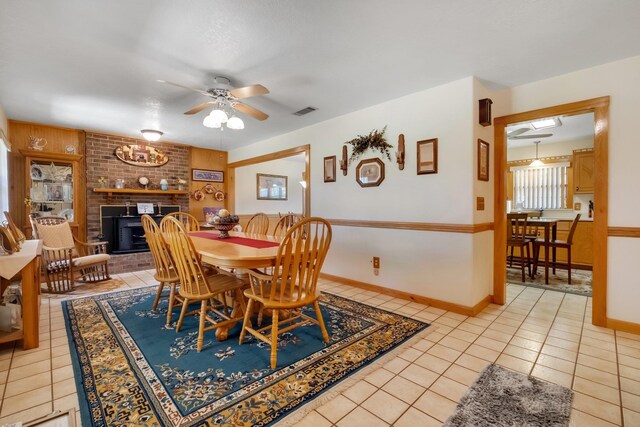 5481 Turner Rd, Perry, FL 32348 - dining room with light tile patterned floors, a ceiling fan, and a fireplace