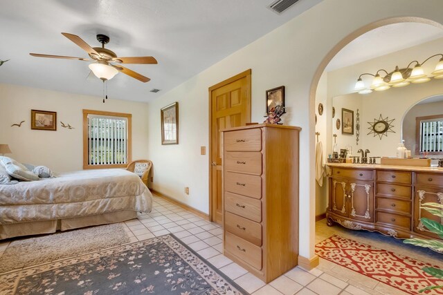 5481 Turner Rd, Perry, FL 32348 - bedroom with arched walkways, light tile patterned flooring, baseboards, and ceiling fan
