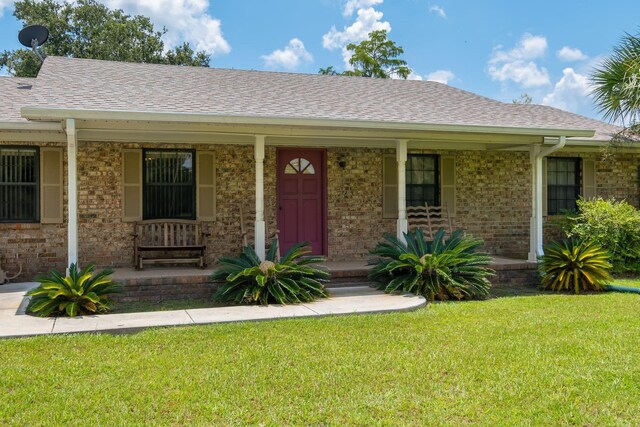 5481 Turner Rd, Perry, FL 32348 - ranch-style home featuring covered porch, roof with shingles, a front yard, and brick siding