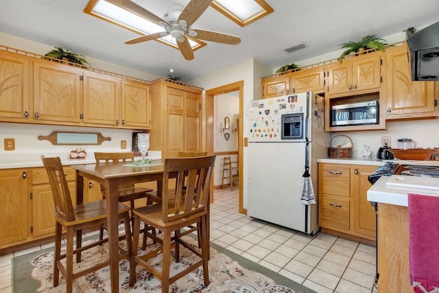 5481 Turner Rd, Perry, FL 32348 - kitchen featuring white refrigerator with ice dispenser, stainless steel microwave, light countertops, ceiling fan, and extractor fan