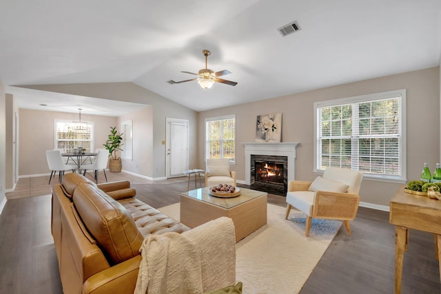 living room featuring hardwood / wood-style flooring, plenty of natural light, a premium fireplace, and vaulted ceiling