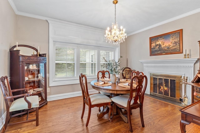 1244 Salem Rd, Havana, FL 32333 - dining area with crown molding, baseboards, light wood-style floors, a chandelier, and a fireplace with flush hearth