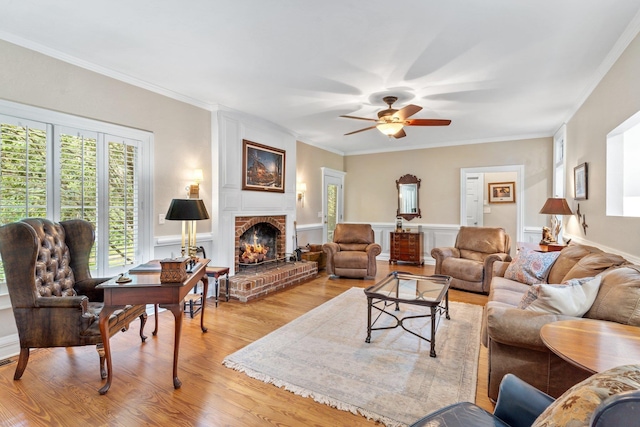 1244 Salem Rd, Havana, FL 32333 - living area featuring ceiling fan, light wood-style flooring, a fireplace, crown molding, and a wainscoted wall