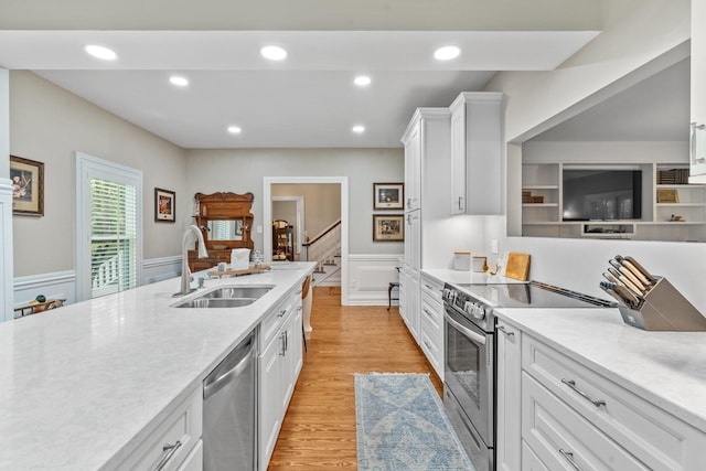 1244 Salem Rd, Havana, FL 32333 - kitchen with a sink, stainless steel appliances, white cabinetry, a wainscoted wall, and light wood finished floors