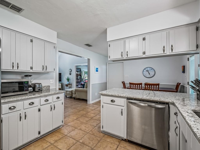 kitchen featuring white cabinetry, light stone counters, and appliances with stainless steel finishes