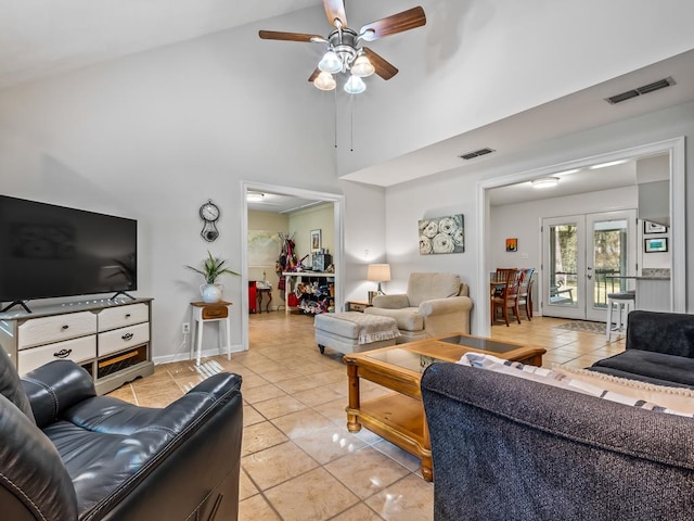 tiled living room with ceiling fan, french doors, and high vaulted ceiling