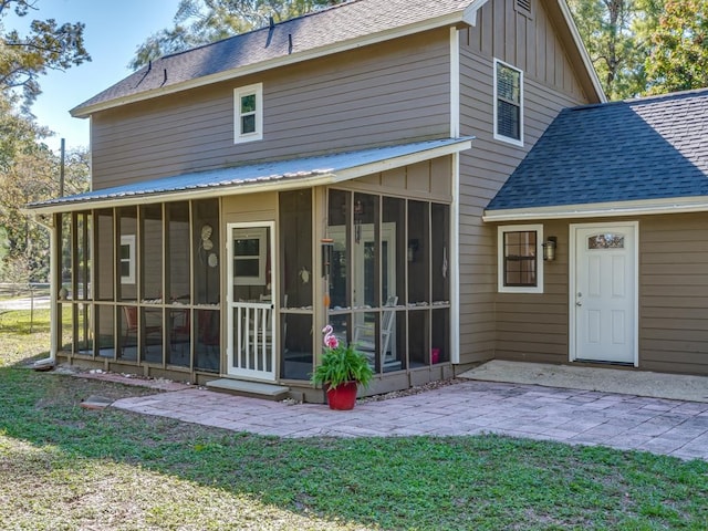 rear view of house featuring a patio, a sunroom, and a lawn