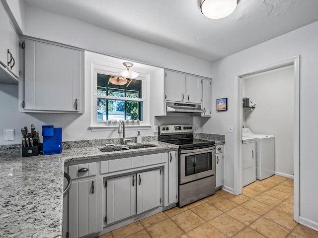 kitchen with light tile patterned flooring, washing machine and dryer, stainless steel electric range oven, and sink