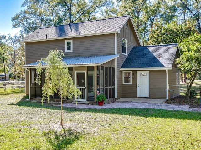 back of property featuring a yard and a sunroom