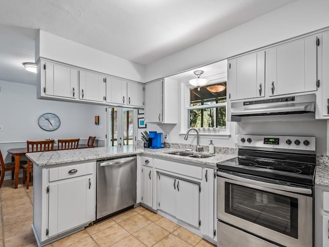 kitchen with white cabinets, sink, light stone counters, kitchen peninsula, and stainless steel appliances