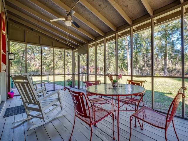 unfurnished sunroom with ceiling fan, plenty of natural light, and vaulted ceiling