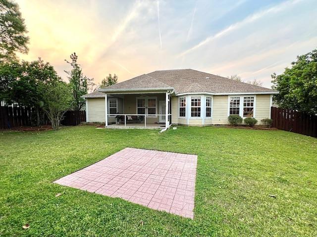 2541 Lagrange Trl, Tallahassee, FL 32312 - rear view of house featuring a sunroom, a ceiling fan, a patio area, and a fenced backyard