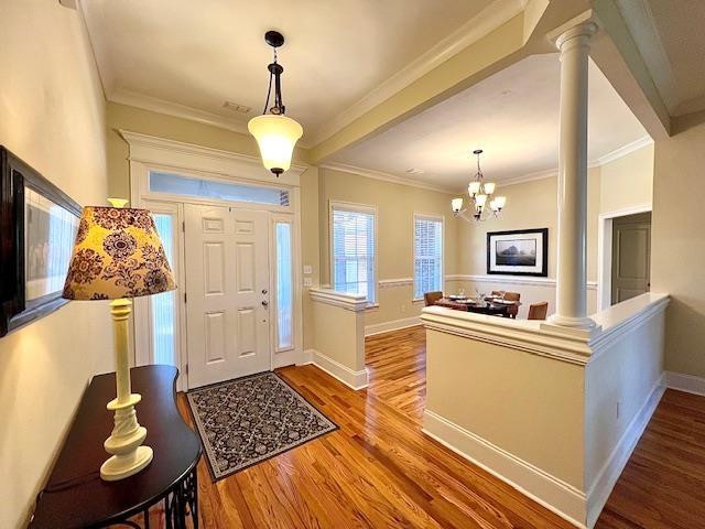 2541 Lagrange Trl, Tallahassee, FL 32312 - foyer entrance with ornate columns, a chandelier, wood finished floors, and crown molding