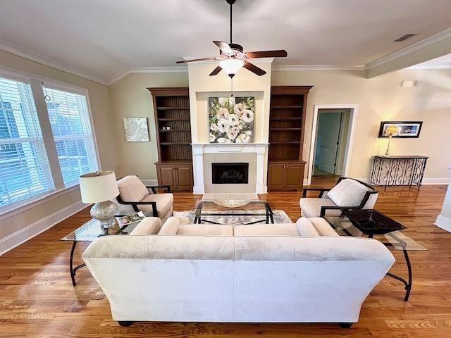 2541 Lagrange Trl, Tallahassee, FL 32312 - living area featuring ceiling fan, ornamental molding, a fireplace with flush hearth, and light wood finished floors