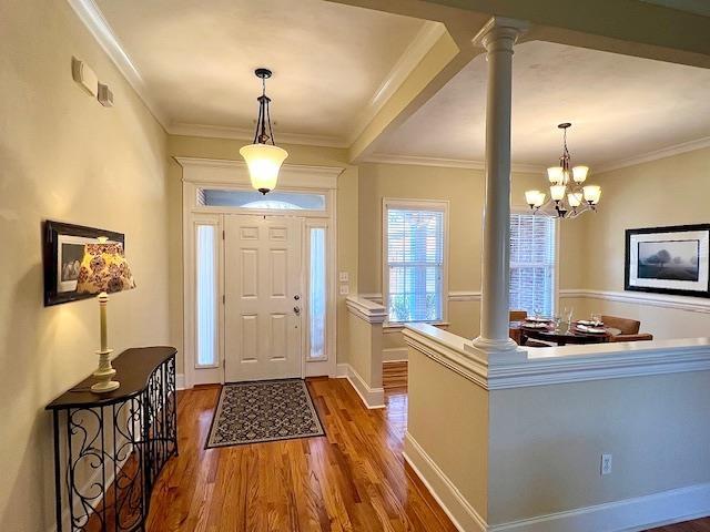 2541 Lagrange Trl, Tallahassee, FL 32312 - entrance foyer with ornate columns, dark wood-style floors, a chandelier, and ornamental molding