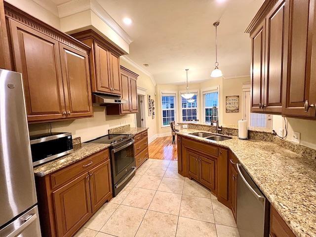 2541 Lagrange Trl, Tallahassee, FL 32312 - kitchen with appliances with stainless steel finishes, under cabinet range hood, crown molding, light stone countertops, and light tile patterned flooring