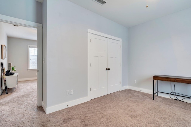 bedroom featuring light carpet and a closet