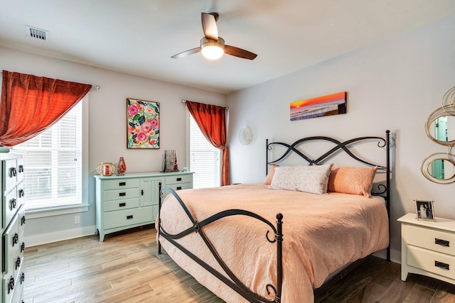 bedroom featuring multiple windows, ceiling fan, and light hardwood / wood-style floors