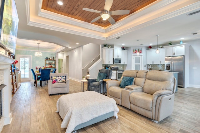 living room featuring crown molding, a tray ceiling, light hardwood / wood-style floors, and wooden ceiling