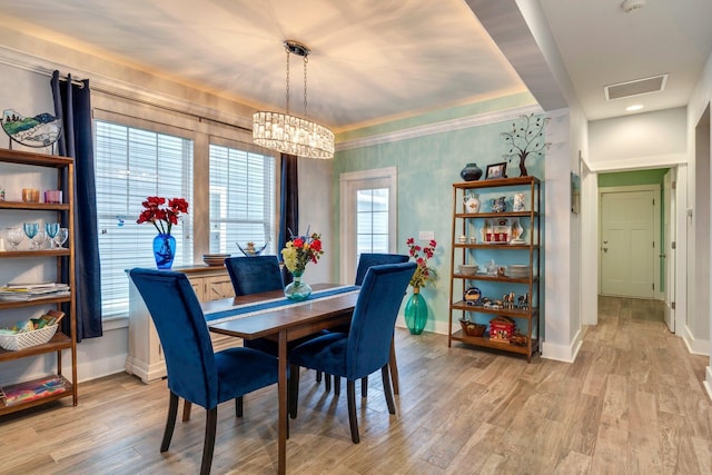 dining room with a notable chandelier and light wood-type flooring