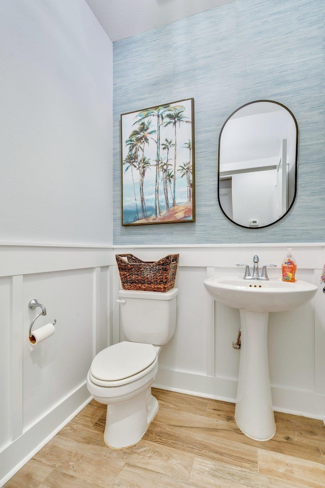 bathroom with hardwood / wood-style floors and toilet