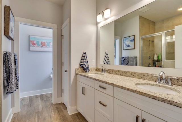 bathroom with vanity, a shower with shower door, and hardwood / wood-style floors