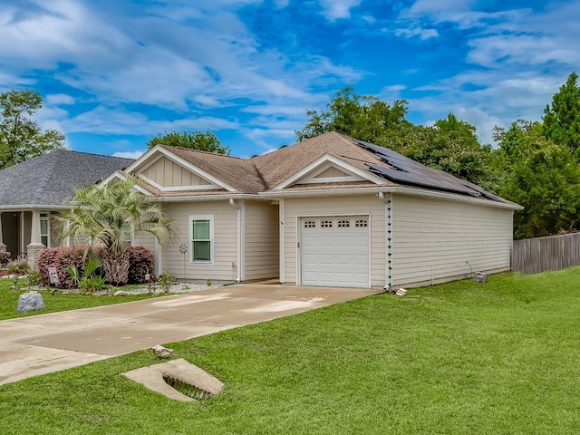 ranch-style house with a garage, a front yard, and solar panels