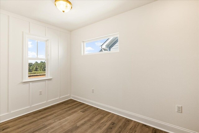 unfurnished room with a healthy amount of sunlight and dark hardwood / wood-style flooring