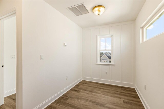 spare room featuring dark hardwood / wood-style flooring and plenty of natural light