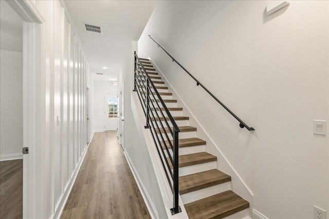 staircase with hardwood / wood-style floors