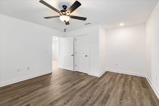 unfurnished bedroom featuring dark wood-type flooring and ceiling fan