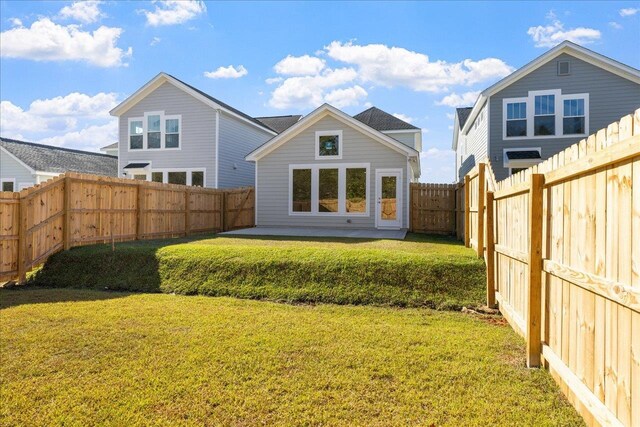 rear view of house featuring a patio and a yard