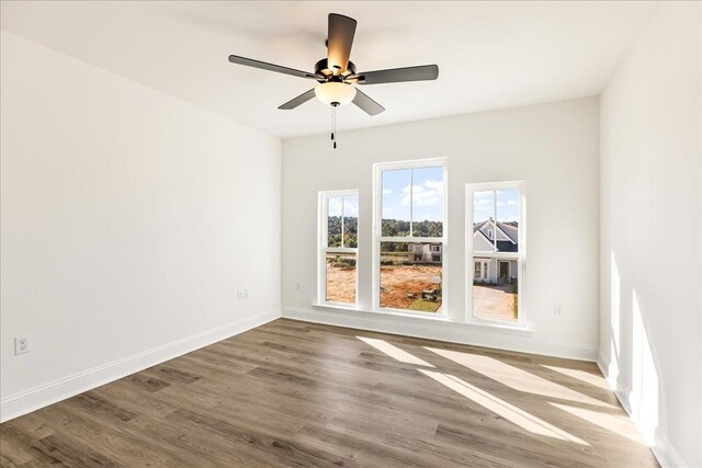 empty room with hardwood / wood-style flooring and ceiling fan