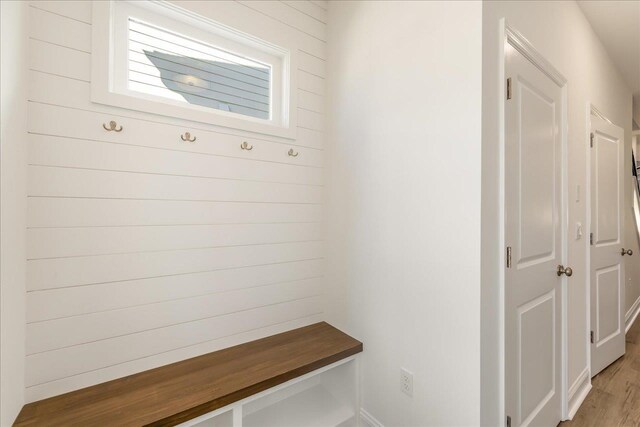 mudroom featuring wood walls and light hardwood / wood-style floors