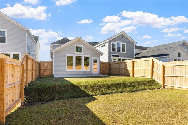 rear view of house with a patio and a yard