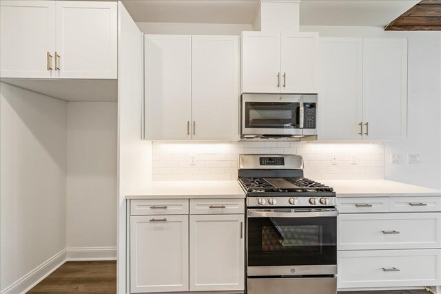 kitchen with white cabinetry, decorative backsplash, dark hardwood / wood-style floors, and stainless steel appliances