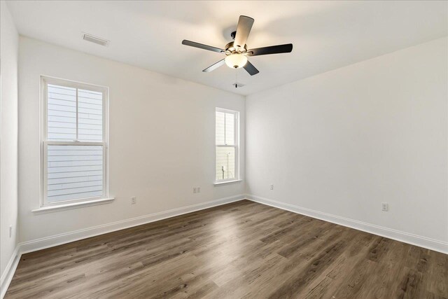 empty room with dark wood-type flooring and ceiling fan