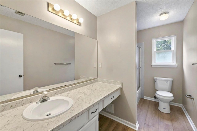 1538 Mclawrence Way, Tallahassee, FL 32317 - full bathroom with wood finished floors, toilet, vanity, baseboards, and enclosed tub / shower combo