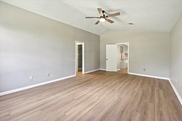 1538 Mclawrence Way, Tallahassee, FL 32317 - unfurnished bedroom featuring lofted ceiling, light wood finished floors, baseboards, a walk in closet, and a textured ceiling