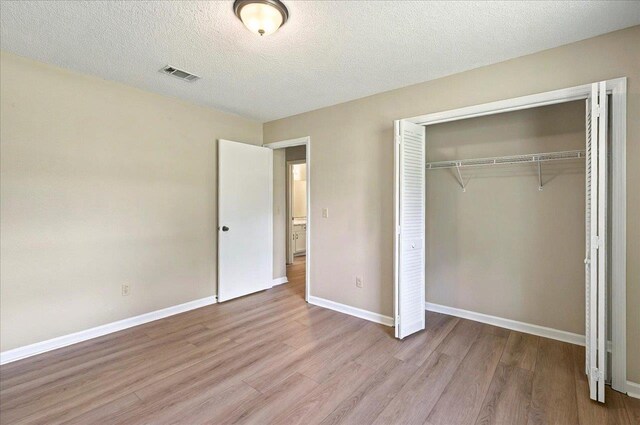1538 Mclawrence Way, Tallahassee, FL 32317 - unfurnished bedroom featuring wood finished floors, a closet, baseboards, and a textured ceiling
