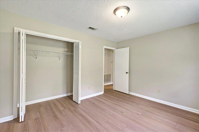 1538 Mclawrence Way, Tallahassee, FL 32317 - unfurnished bedroom featuring wood finished floors, a closet, baseboards, and a textured ceiling
