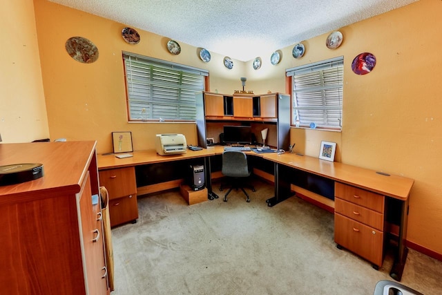 carpeted office featuring built in desk and a textured ceiling