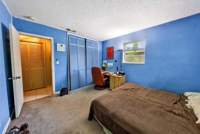 bedroom with carpet floors and a textured ceiling