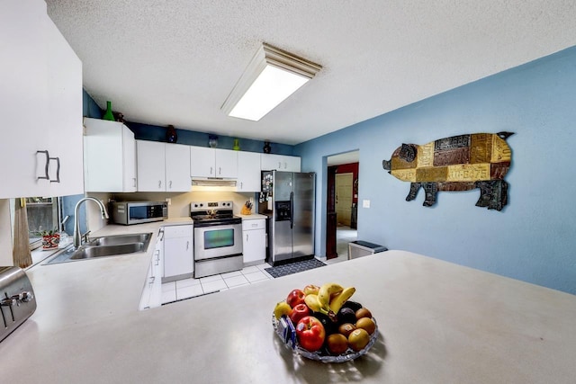 kitchen featuring appliances with stainless steel finishes, a textured ceiling, white cabinetry, and sink