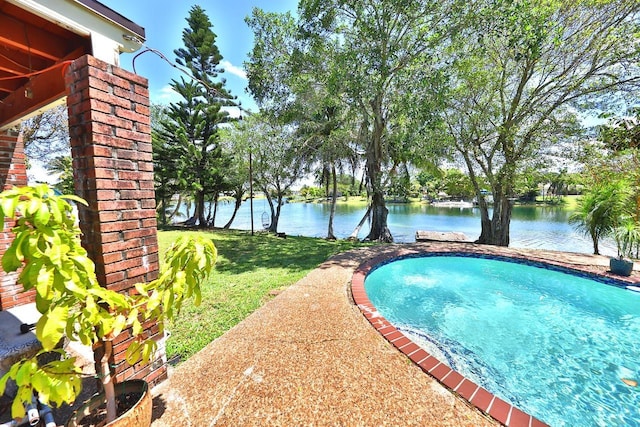 view of swimming pool featuring a yard and a water view