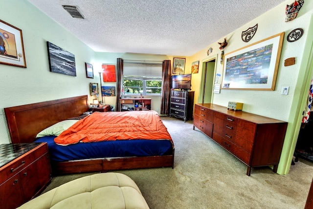 bedroom with a textured ceiling and light carpet