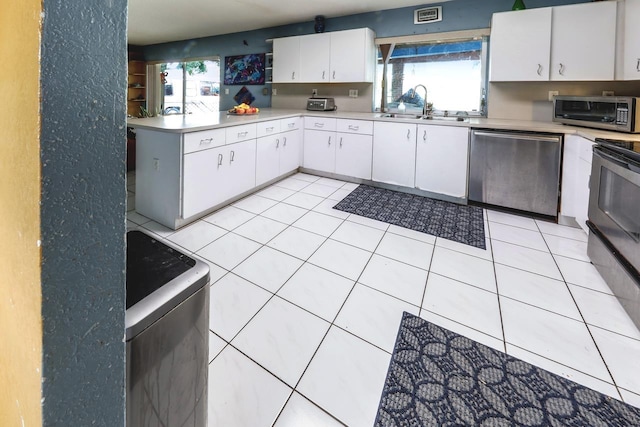 kitchen featuring sink, white cabinetry, stainless steel appliances, and a wealth of natural light