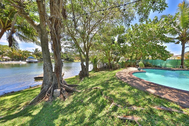 view of swimming pool featuring a yard and a water view